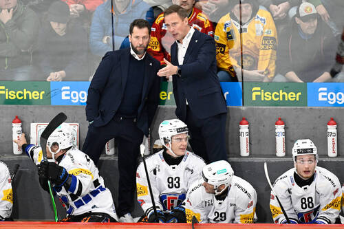 Fribourgs Ass. Coach Lars Leuenberger und Head Coach Roger Roennebrg, hinten rechts, beim Eishockey-Qualifikationsspiel der National League, zwischen den SCL Tigers und dem HC Fribourg-Gotteron, am Mittwoch, 28. Oktober 2026, in der Emmental Versicherung Arena in Langnau.(KEYSTONE/Marcel Bieri)