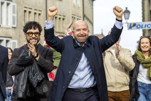 Nicolas Walder, droite, nouvel elu Les Verts au conseil d'Etat, et son mari Jorge  Cadena, gauche, arrivent au lieu de la presentation des resultats du 2e tour du second tour de l'election complementaire du Conseil d'Etat genevois provoquee par la demission du conseiller d'Etat Antonio Hodgers, ce dimanche 19 octobre 2025 a Geneve. Apres la demission d'Antonio Hodgers, les Verts conservent leur siege au Conseil d'Etat genevois. Selon les resultats anticipes, Nicolas Walder a 4558 voix d'avance sur l'UDC Lionel Dugerdil dimanche, au second tour de l'election partielle. (KEYSTONE/Salvatore Di Nolfi)